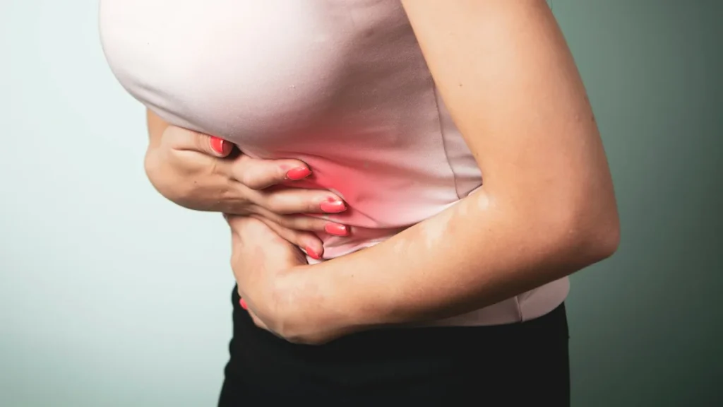 Woman pressing her left side under the ribs, where spleen pain is usually felt